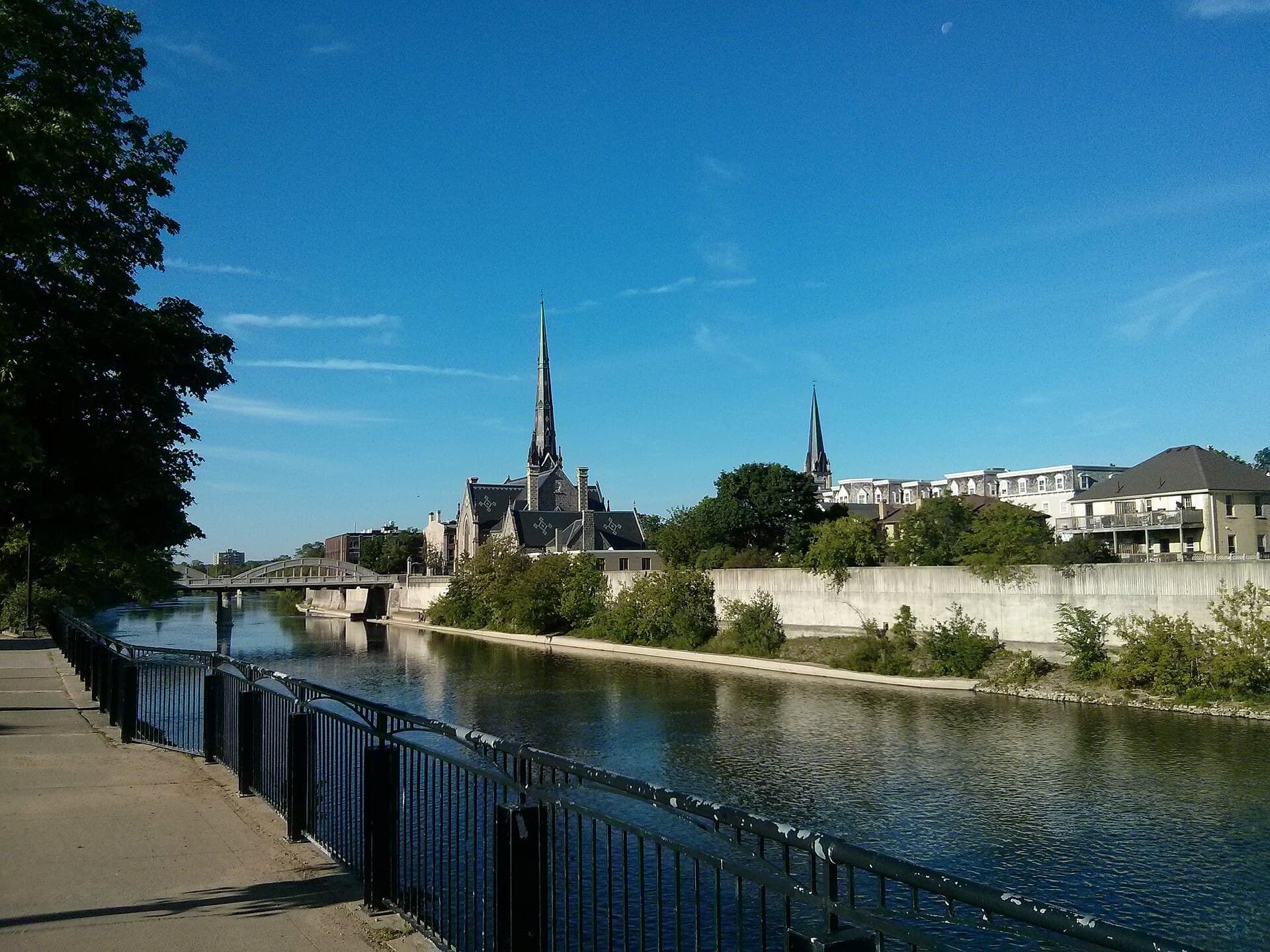 The riverside walkway along the Grand River approaching the spires of downtown Galt, Cambridge
